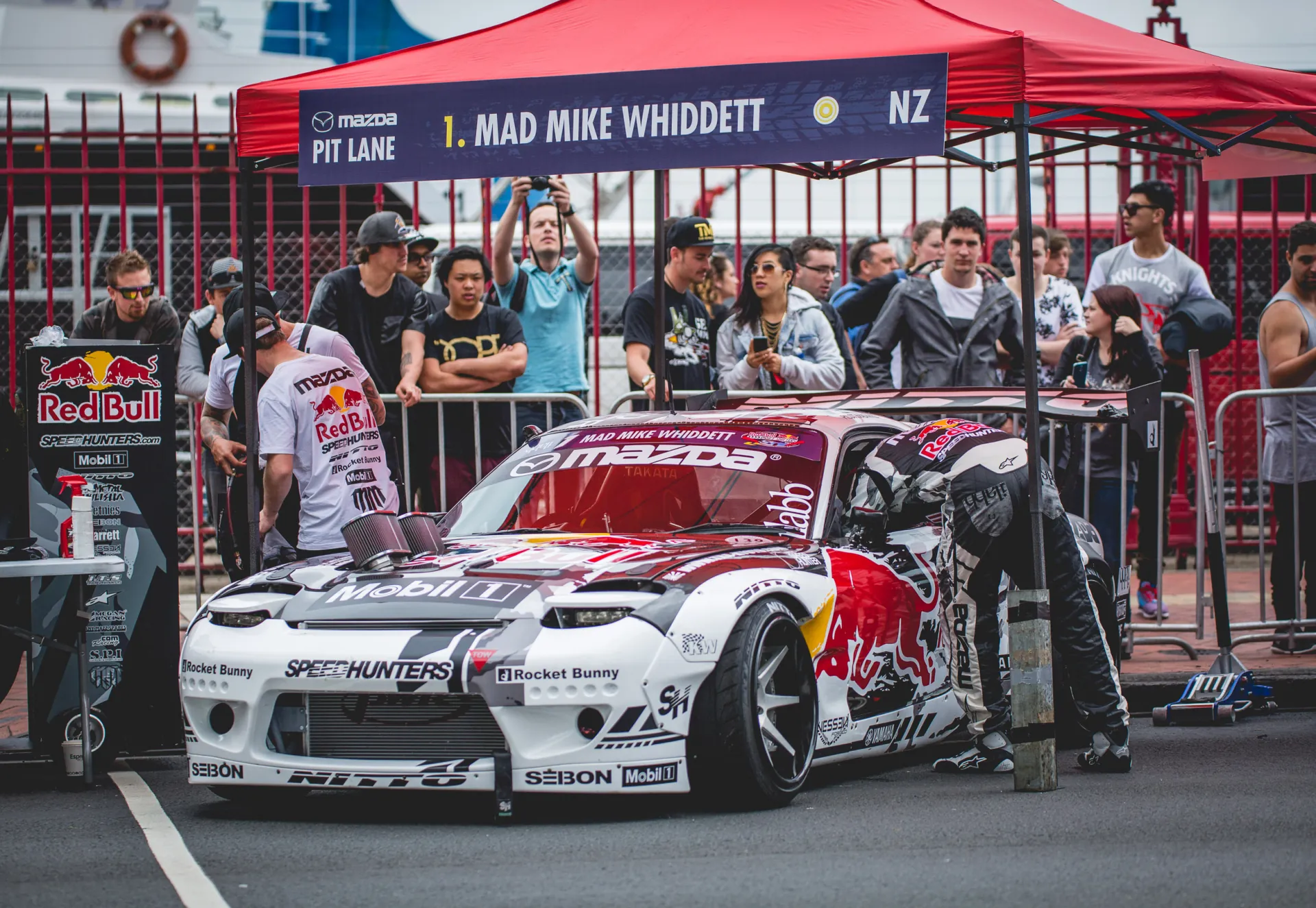 Mad Mike Whiddett’s drift car in the pit lane, fans behind the barrier.