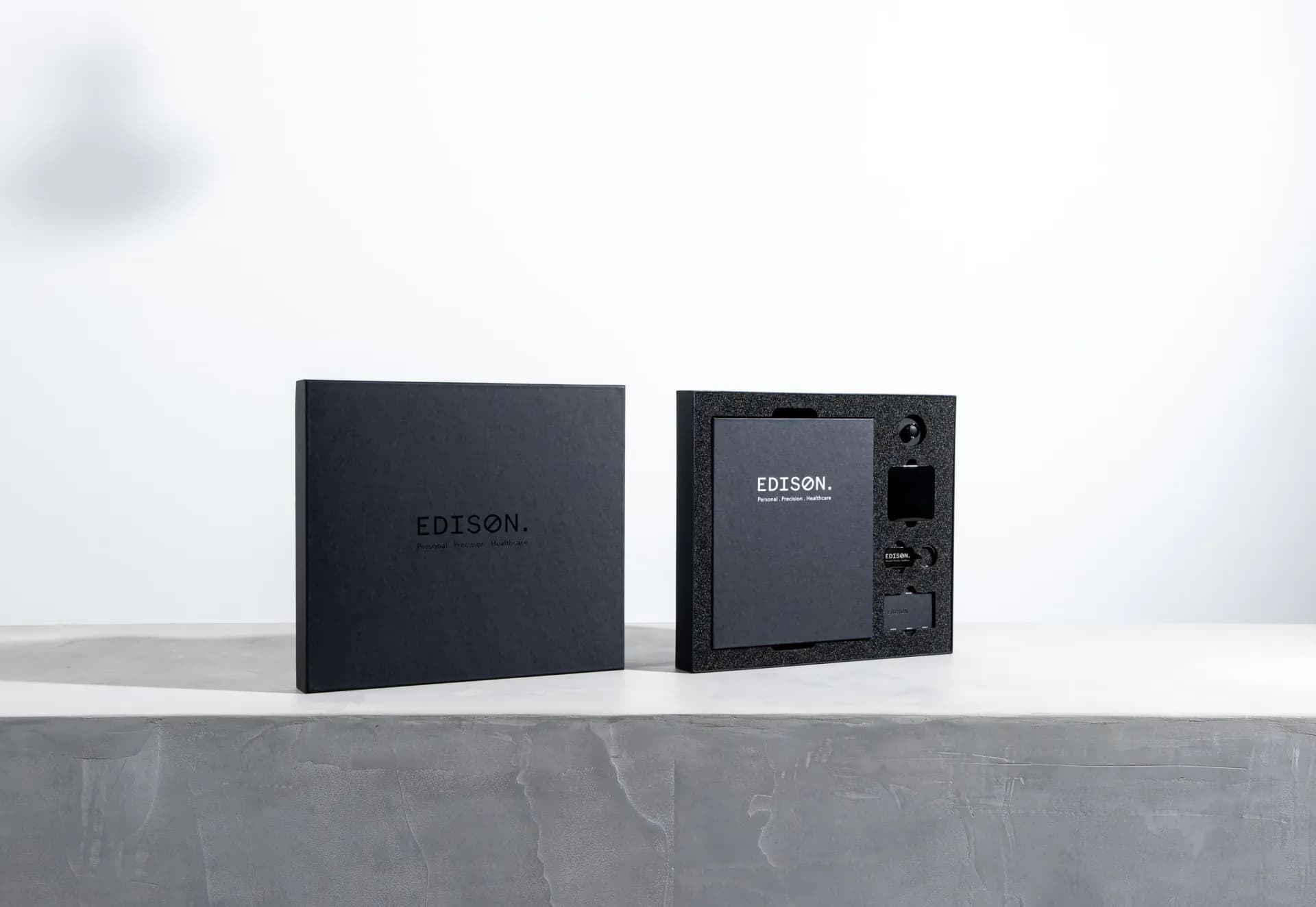 A closed Edison box beside an open kit, both standing upright.