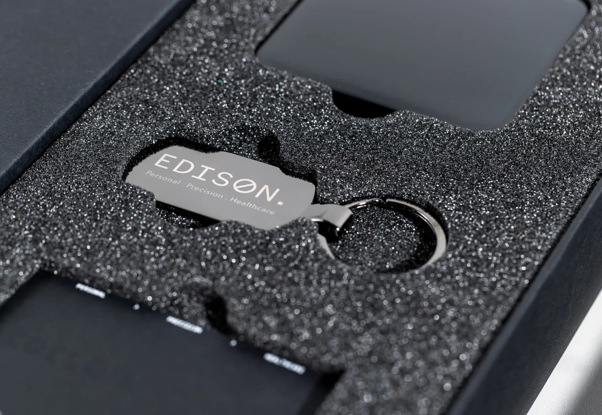 The Edison keyring set into black foam, close up.