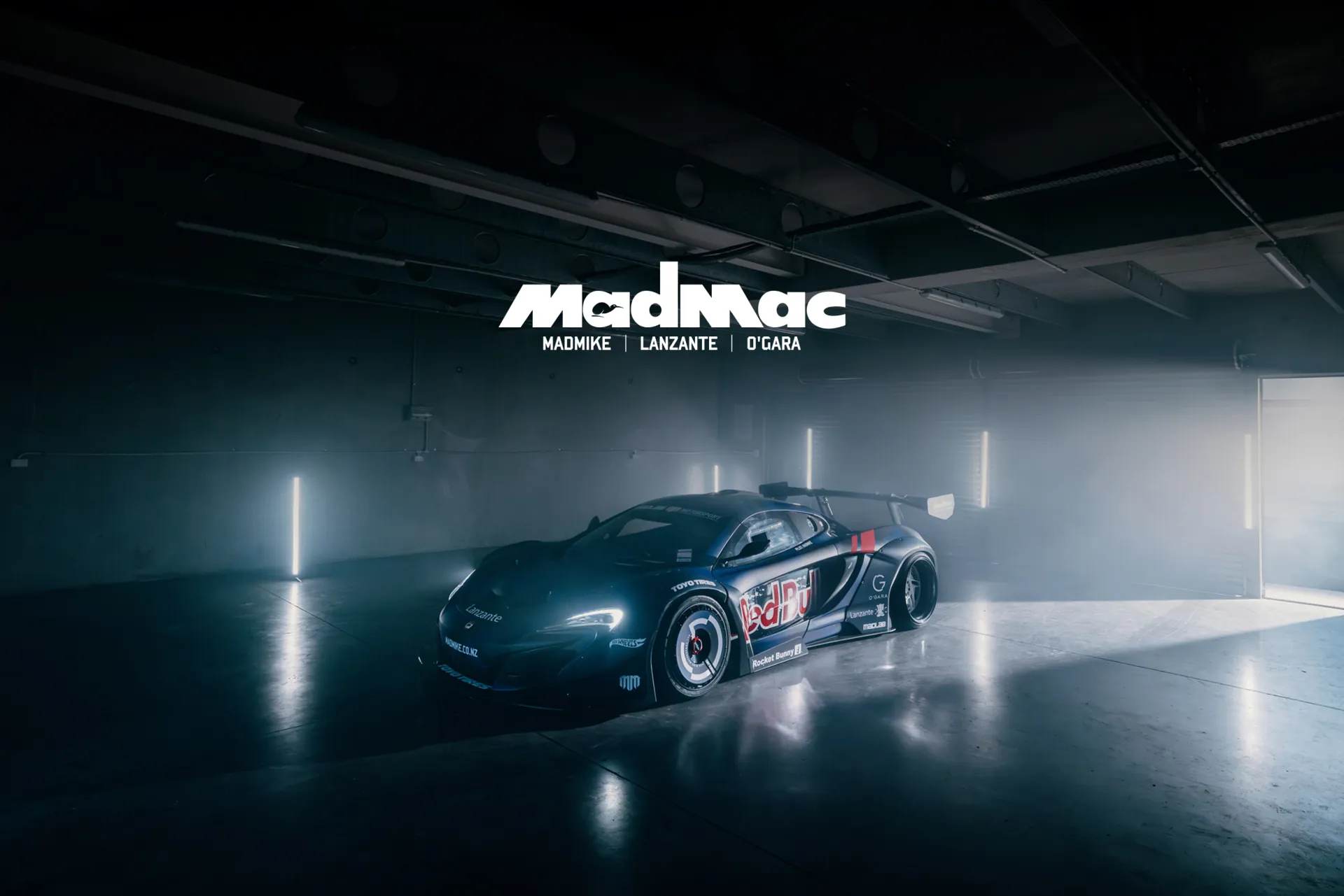 The MADMAC car lit in a dark studio beneath the MadMac wordmark.