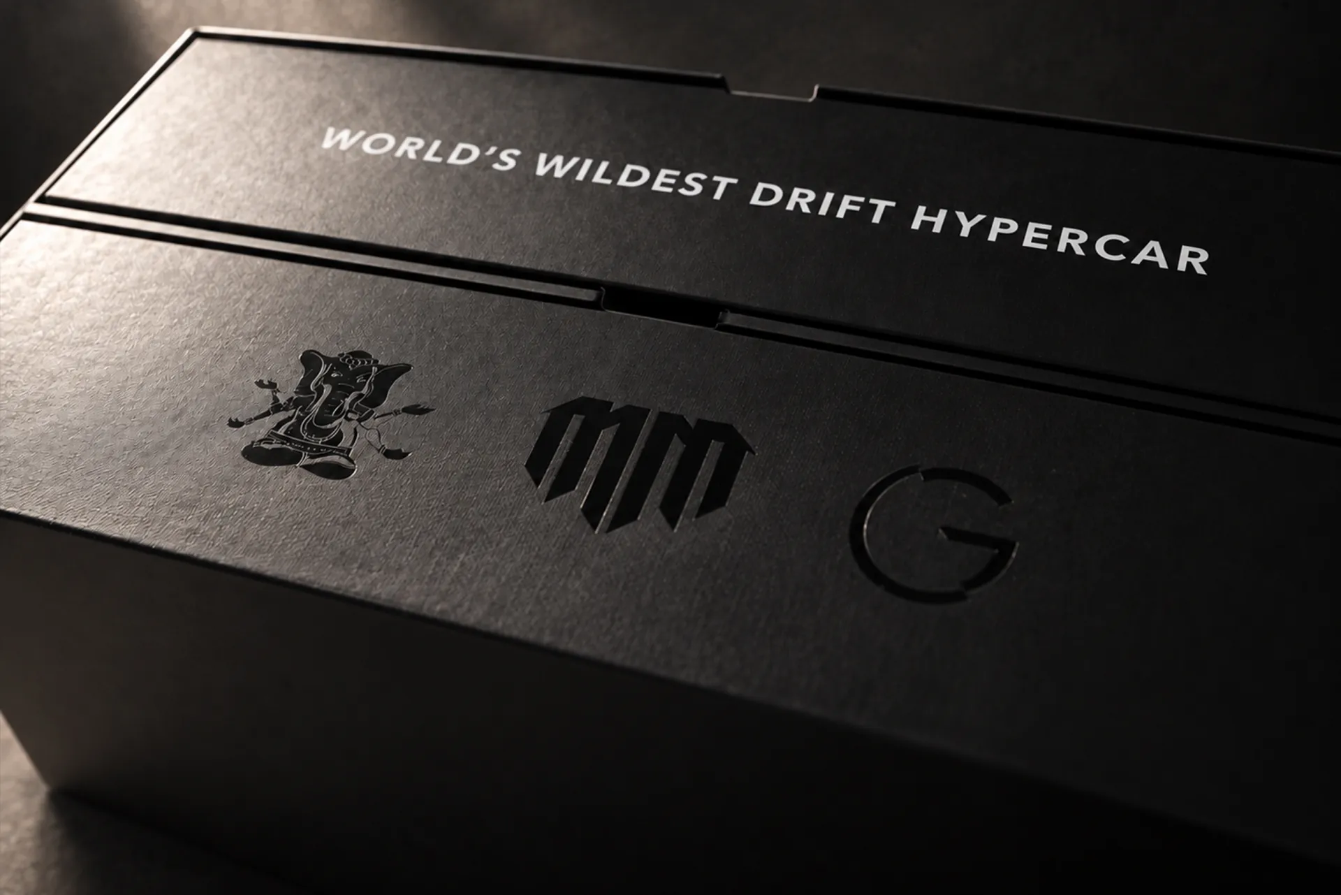The MadMac box lid, “World’s wildest drift hypercar” above three embossed marks.