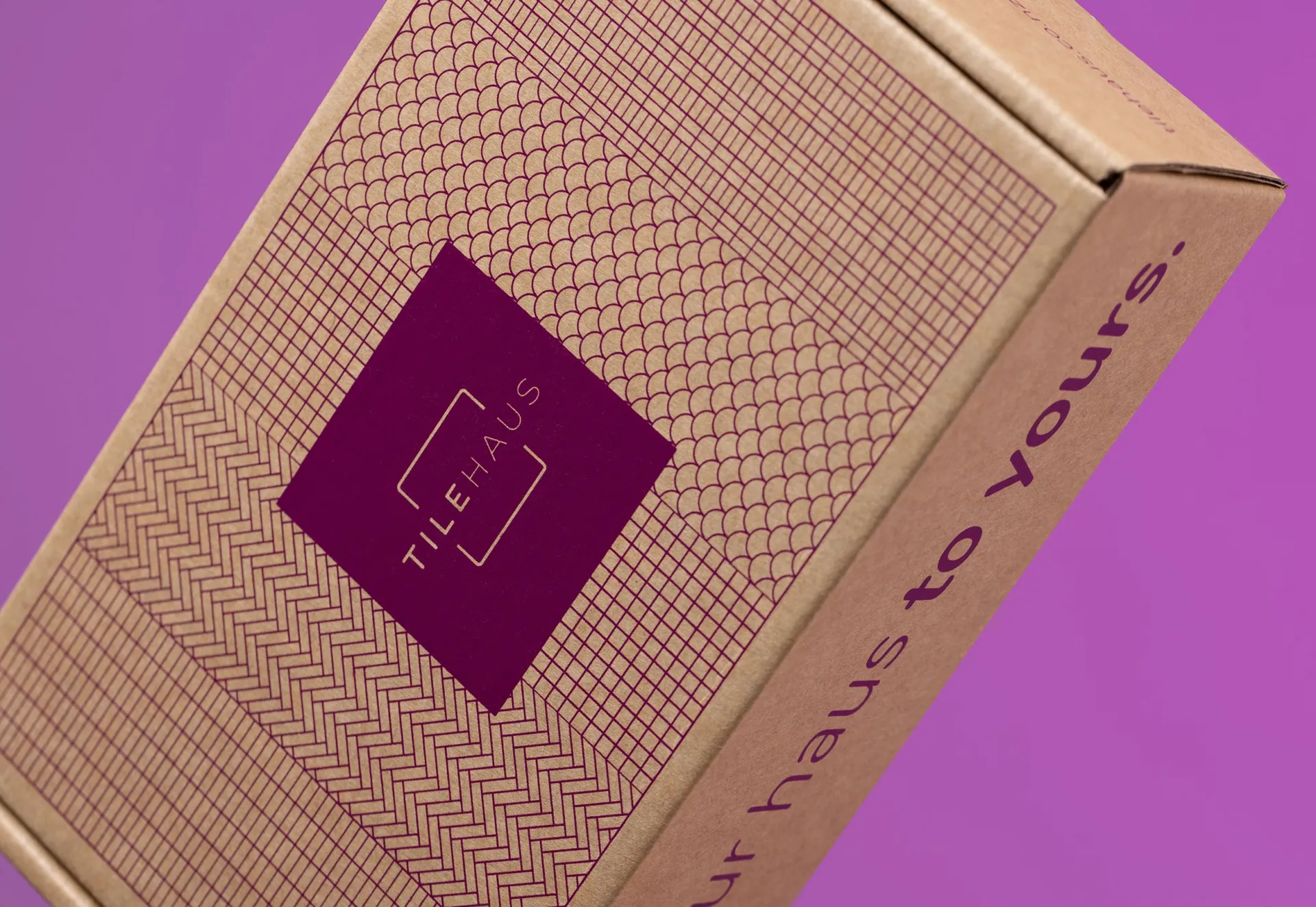 A close view of the kraft TileHaus box, its plum label and “to yours.” printed down its side.